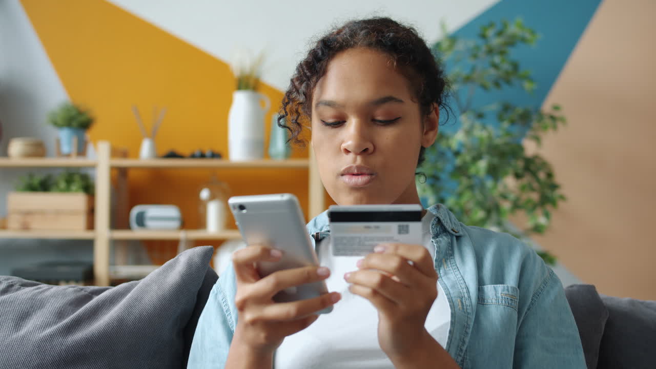 Adolescente che effettua un pagamento online con una carta di credito e uno smartphone