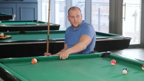 adult men with disabilities in a wheelchair play billiards in the club