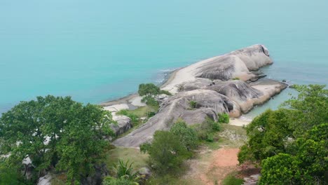 large granite boulders on pantai penyabong shoreline surrounded