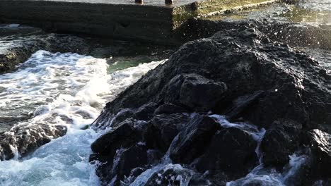 rock seaside shore. close up view of waves in sea smashing against rocks