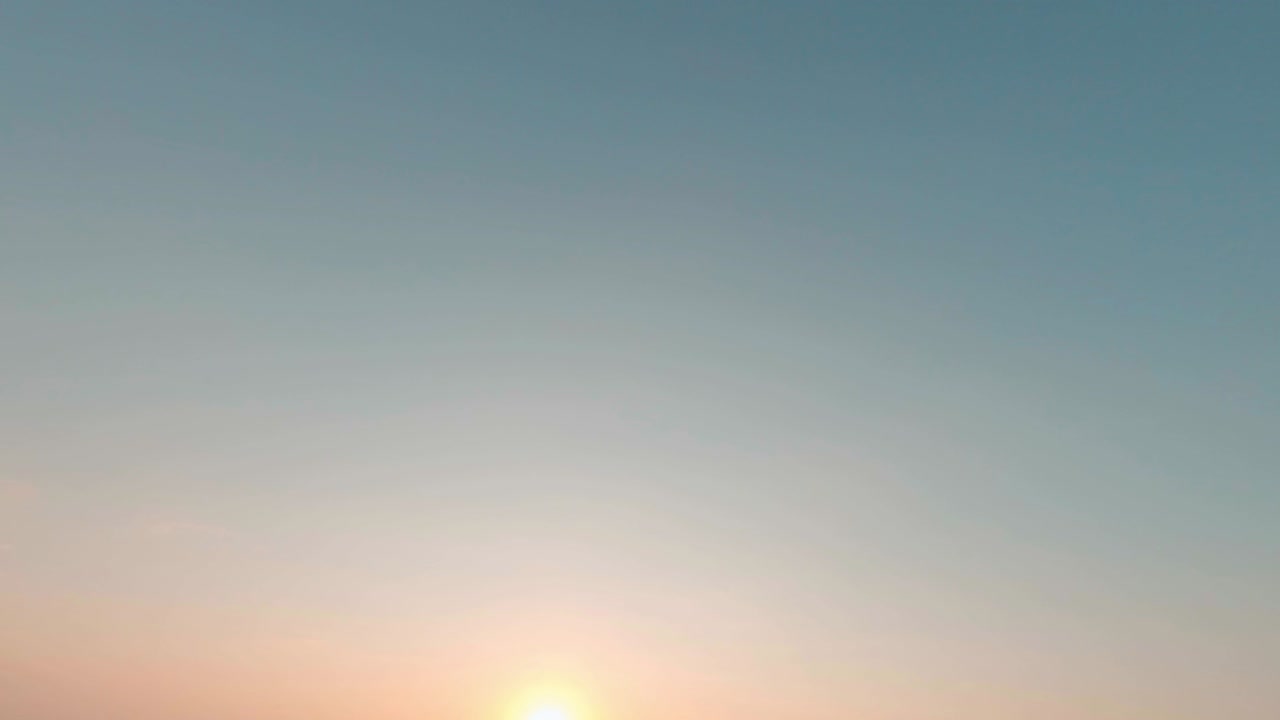 레이싱 fpv 드론 자유 스타일 비행, 루프 및 회전, 건조한 식물과 푸른 나무가있는 넓은  위에서, 밝은 저녁 여름 해가 지는 은 푸른 하늘 아래.