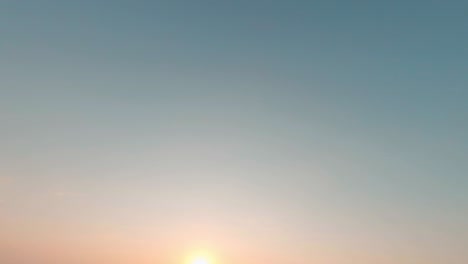 레이싱 fpv 드론 자유 스타일 비행, 루프 및 회전, 건조한 식물과 푸른 나무가있는 넓은  위에서, 밝은 저녁 여름 해가 지는 은 푸른 하늘 아래.