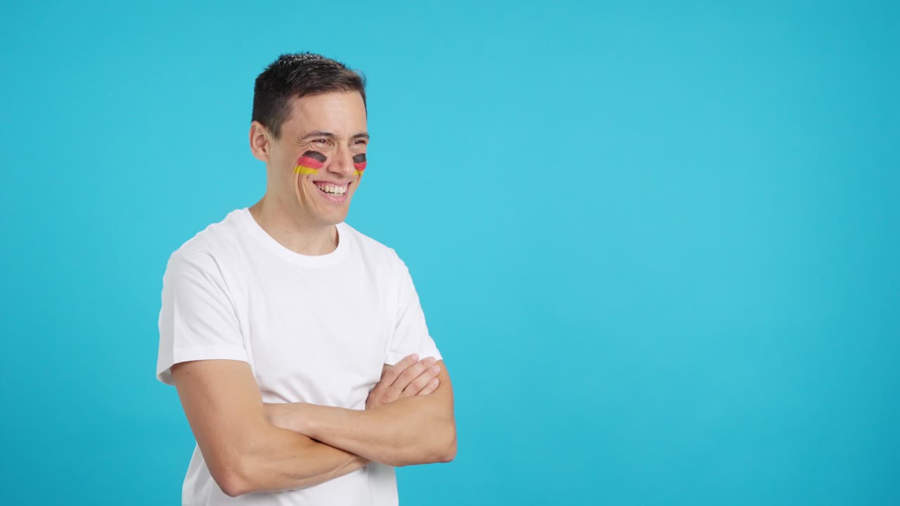 Homem feliz com a bandeira alemã pintada no rosto, olhando para longe