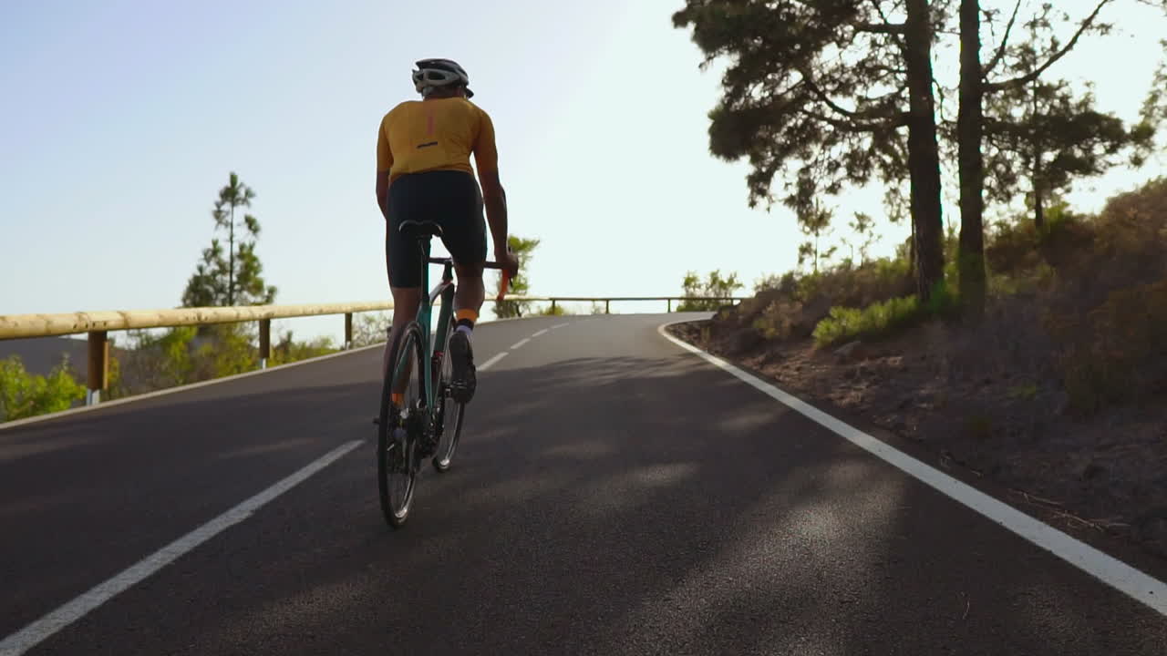 도로 자전거를 타고 있는 자전거 타는 사람, 조용한 아침 도로에서 야외 운동을 즐기는 사람. 슬로우 모션 묘사는 익스트림 스포츠의 경험을 높입니다.