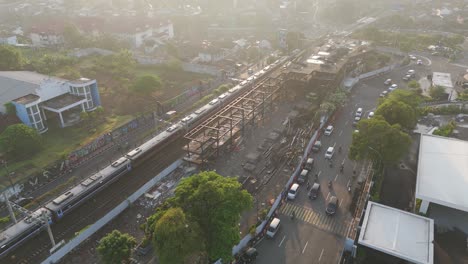 aerial: passenger train departing yogyakarta railway station during the day in special region of yogyakarta, indonesia, establishing drone shot