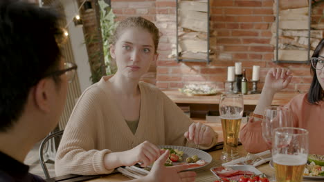 young woman having a good time with her multicultural group of friends at a dinner party 1