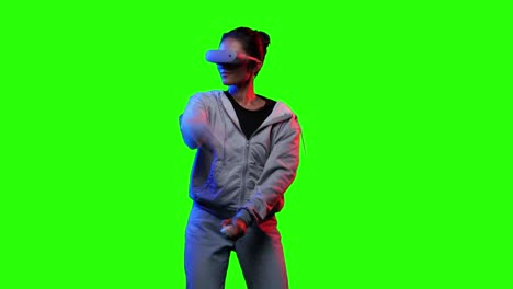 asian women playing video games in modern vr headset with chroma key green screen. gamer female controlling joysticks and fighting virtual in video game online. concept of digitals and esport games.