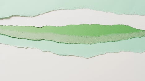 video of close up of torn pieces of green and white paper background