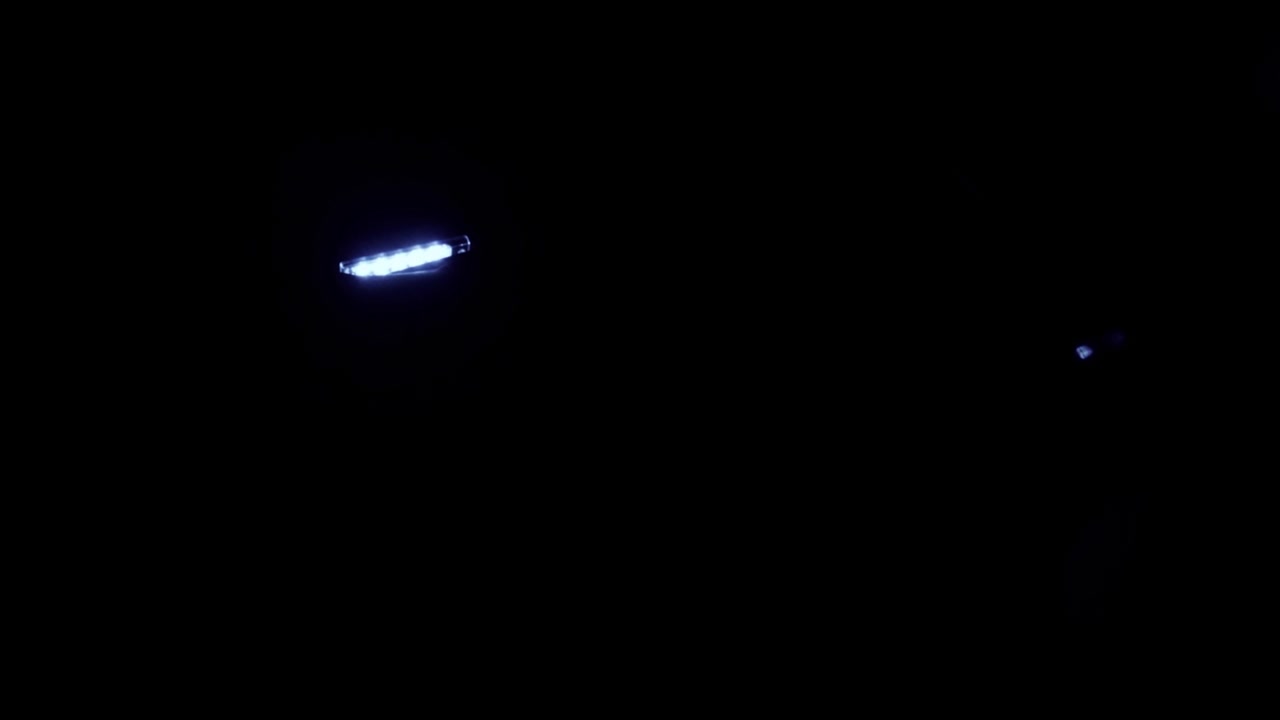Abstrakte blaue Lichtstreifen und Lens Flare in der Dunkelheit