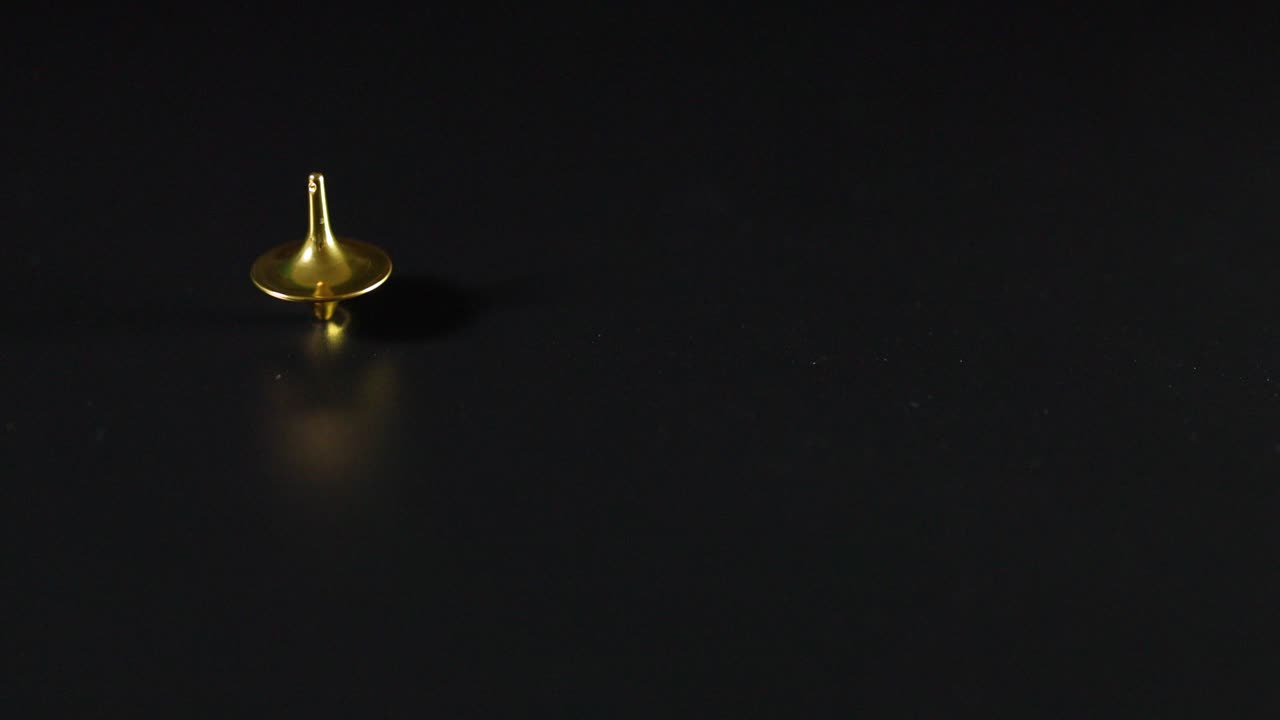 giratorio dorado girando en una superficie oscura