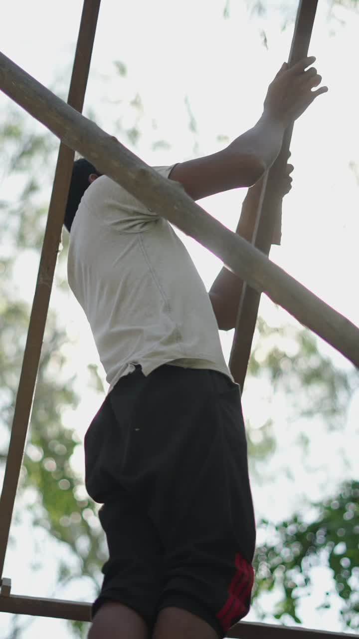 Person climbing a structure against the sun