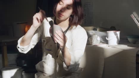 Young-female-potter-working-in-her-studio