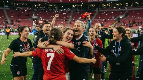 celebration of victory: a heartwarming scene captured as players and coaches embrace in joyful exuberance, surrounded by confetti and team spirit after a hard-won match