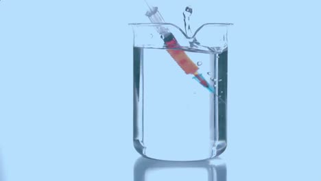 Animation-of-red-shapes-rotating-over-syringe-with-reagent-in-glass-on-blue-background