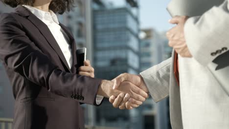 business people shaking hands on street