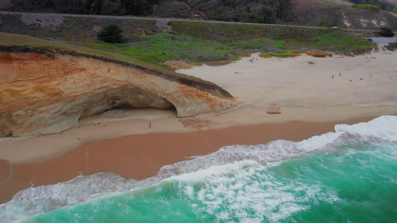 Aerial view drone shot of California Coastline with people in the background