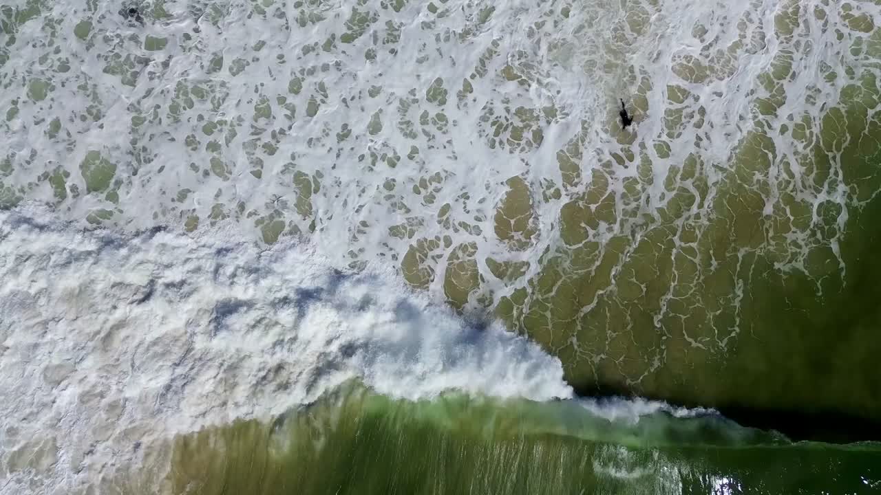 Short drone video of a surfer battling against the waves during cyclone season in Australia