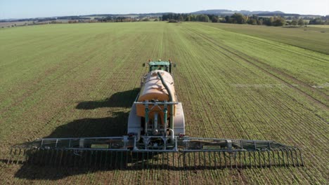 liquid manure spreader releasing slurry on field aerial view