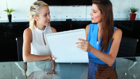 female executives discussing over chart at desk 4k