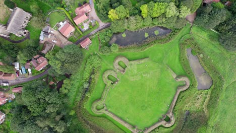 Aerial-video-footage-of-the-remains-of-Bolingbroke-Castle-a-13th-century-hexagonal-castle,-birthplace-of-the-future-King-Henry-IV,-with-adjacent-earthwork