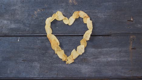 potato chips forming a heart shape with copy space on wooden surface