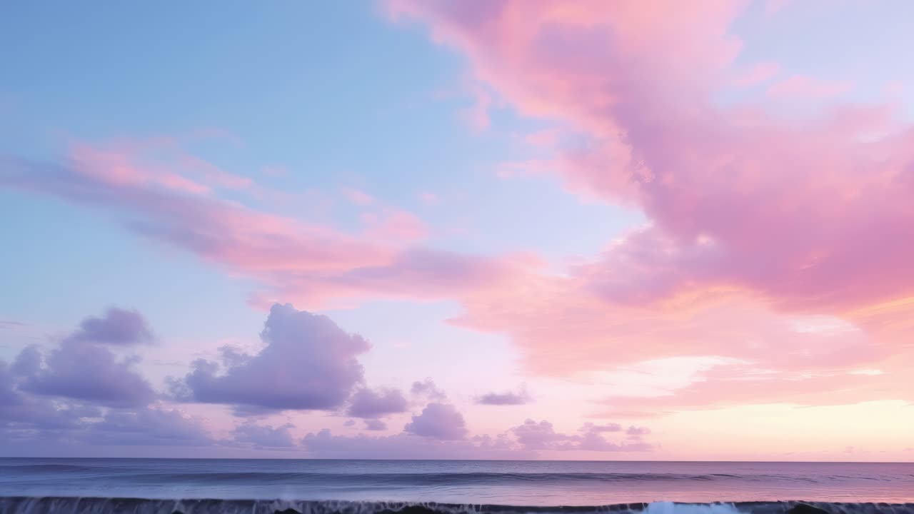 Un sereno paesaggio marino al tramonto con nuvole rosa pastello e blu. Acquisito da un angolo basso, perfetto