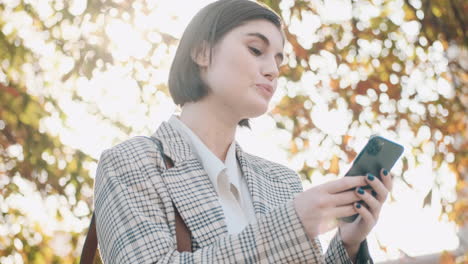 stylish businesswoman using smartphone outdoor.