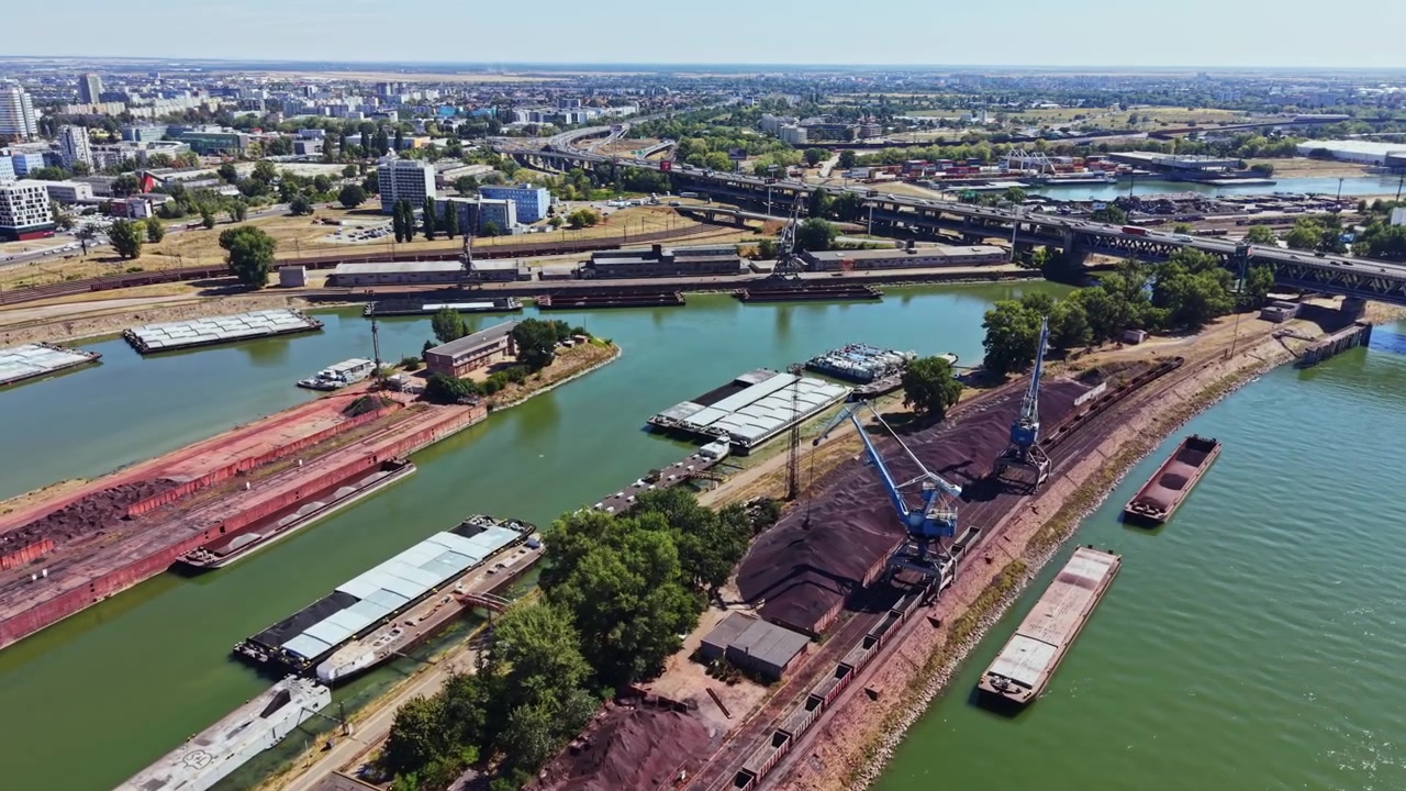 Molte barche e lavori di costruzione lungo un fiume con edifici e strade sullo sfondo in una giornata limpida