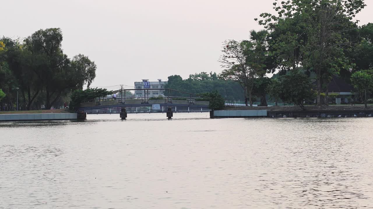 나무 와 멀리 있는 건물 들 이 있는 조용 한 호수