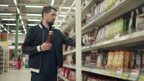 hombre comprando ketchup en un supermercado