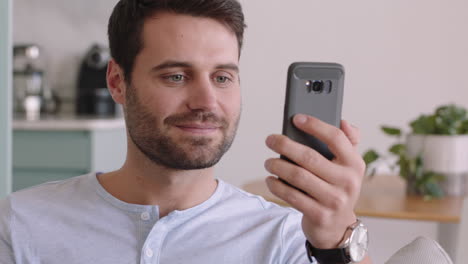 happy young man having video chat using smartphone enjoying chatting online with friend relaxing at home