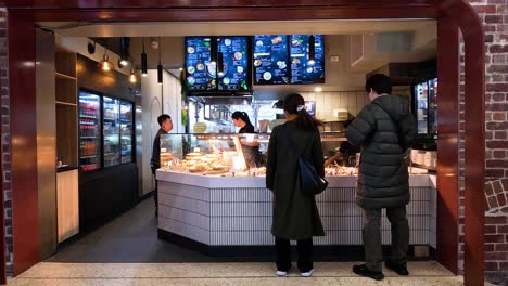 customers interacting at a food shop counter