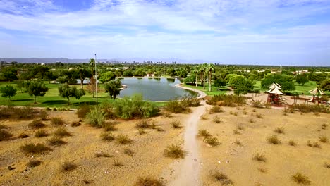 aerial descent​ from high angle view of the phoenix skyline to the desert floor and urban municipal par, in a north central phoenix neighborhood