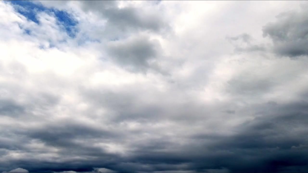 Timelapse of white cumulus clouds drifting across a bright blue sky, capturing natural weather movement and peaceful atmospheric scenery.