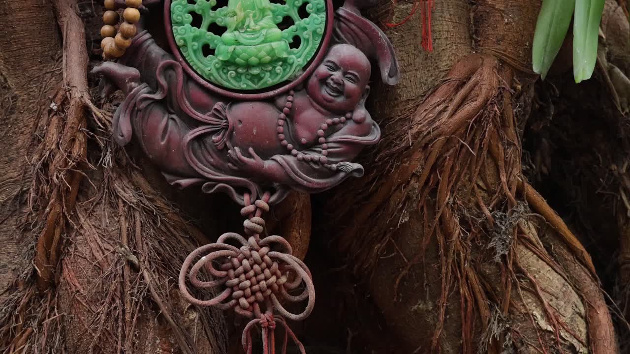 la estatua tallada de buda se balancea en medio de las raíces de los árboles