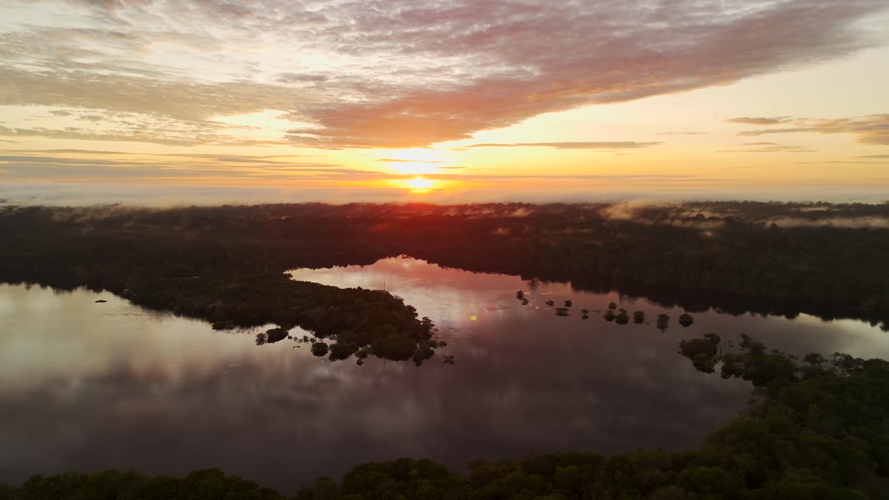 el reflejo naranja del amanecer en las aguas tranquilas del río juma, amazonas, brasil