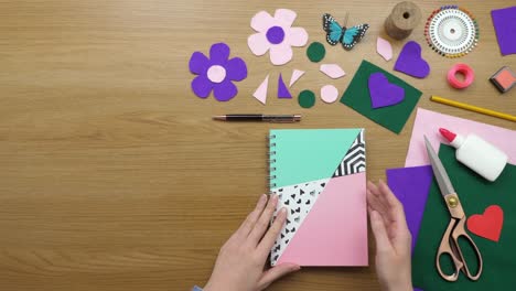 aerial footage of woman writing in diary by craft equipment