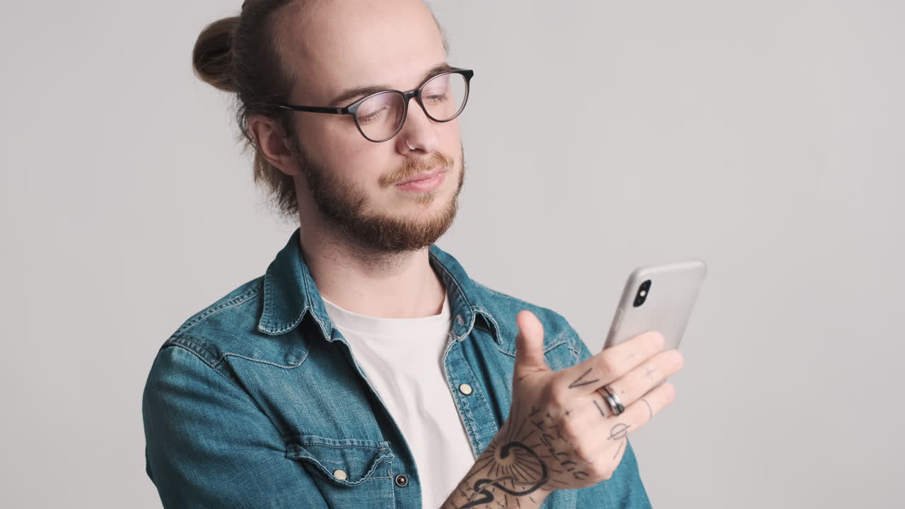 joven caucásico desplazándose en el teléfono inteligente.
