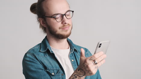 joven caucásico desplazándose en el teléfono inteligente.