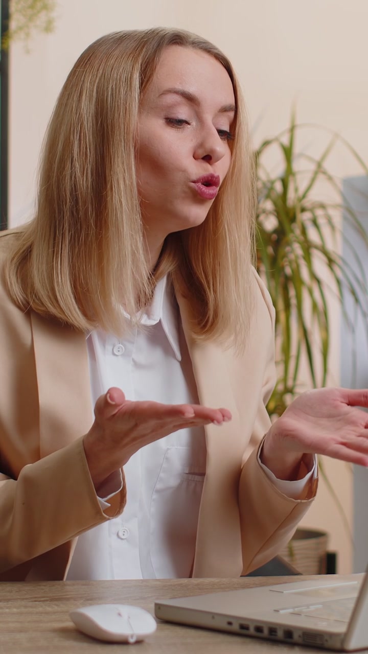 Donna d'affari che lavora al portatile in ufficio parla di comunicazione online video con il capo del dipendente