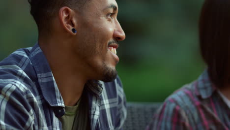 positive friends gathering together outside. african man smiling at summer party