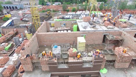 Construction Of The New Building. VINNITSA, UKRAINE - JUNE 2016: Aerial shot of the professional construction worker laying bricks in industrial site