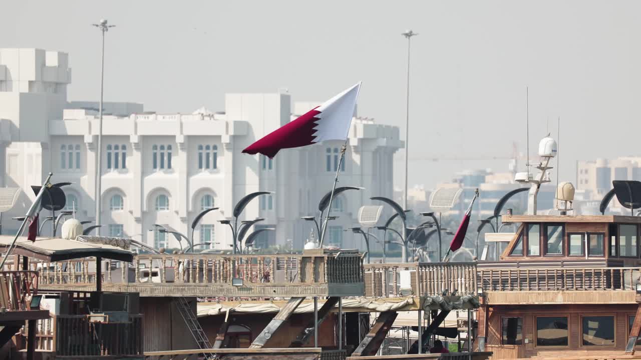 Bandiera del Qatar al rallentatore sul lato di una barca nel porto turistico della città di Doha