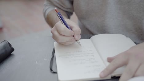 Ein-Männlicher-Student,-Der-Sich-Handschriftlich-Notizen-Macht