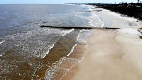 Video-Aéreo-De-La-Playa-Con-Rompeolas-Y-Gente-Pescando-En-Un-Día-Soleado