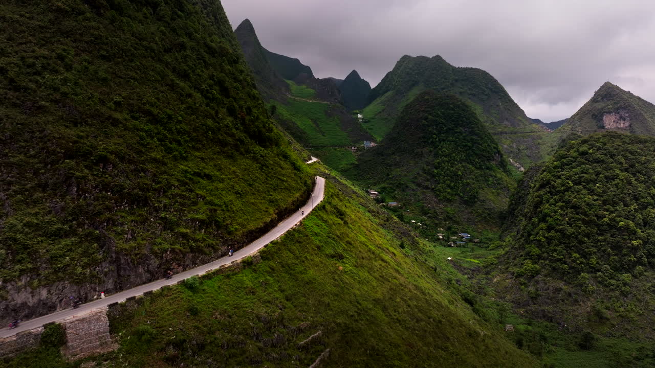 vista aérea de motociclistas en el bucle de ha giang en vietnam, capturando carreteras panorámicas que serpentean a través de montañas verdes