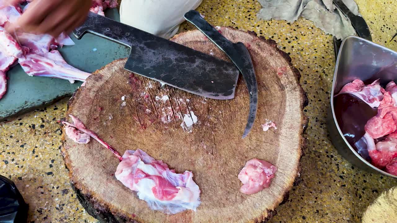 Rustik matberedningsscen med slaktarverktyg och rått kött på skärbräda.