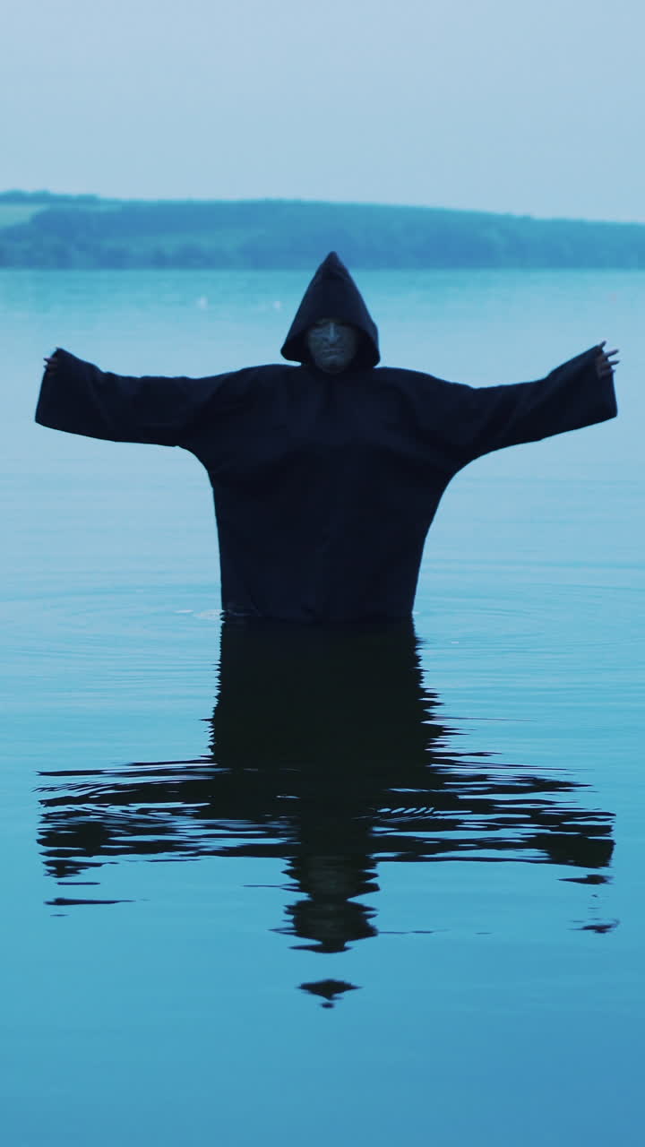 Evil Witch in a Black Hood in the River. Vertical video
