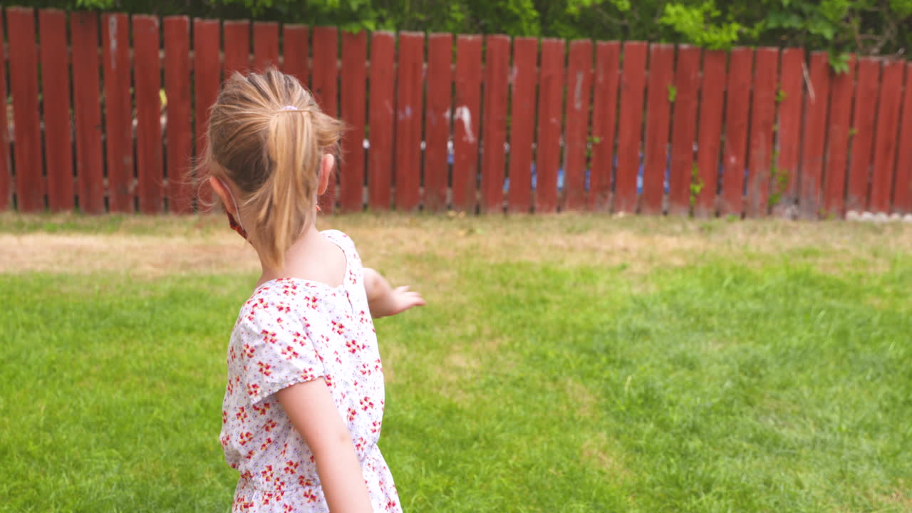 보호용 안면 마스크를 착용한 채 원을 그리며 회전하는 어린 소녀