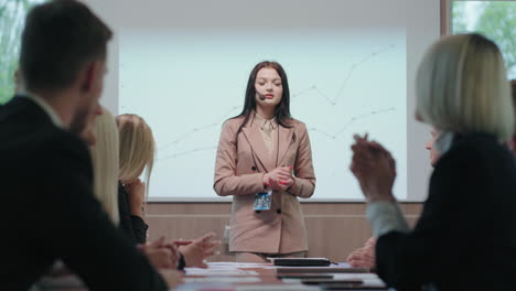 nervous-woman-is-finishing-her-speaking-in-business-meeting-colleagues-are-supporting-her